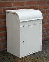 The "Titan" Medium Wall Mounted Parcel Box Steel in Cream Shown Mounted to the Floor next to a Brick Wall