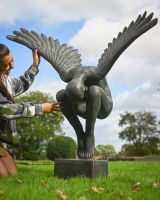 The Zephyr Winged Angel Garden Sculpture Showing a Lady Crouched next to it for Scale