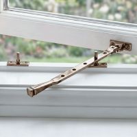 The 12" Polished Bronze Window Stay Mounted on an Open White Window in a Contemporary Home - Digital Illustration The 12" Polished Bronze Window Stay Mounted on an Open White Window in a Contemporary Home - Digital Illustration