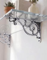 The 12 x 21cm "Luciano" Ornate Scroll Bright Chrome Wall Bracket Mounted on a White Wall in a Modern Home Shown from Underneath - Digital Illustration 