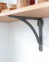 The 14 x 18cm Natural Iron Curved Shelf Bracket Mounted on a White Kitchen Wall in a Contemporary Home - Digital Illustration 