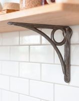 The 16 x 19.5cm Cast Iron Circle Design Shelf Bracket Mounted on a Kitchen on a White Tiled Wall - Digital Illustration The 16 x 19.5cm Cast Iron Circle Design Shelf Bracket Mounted on a Kitchen on a White Tiled Wall - Digital Illustration