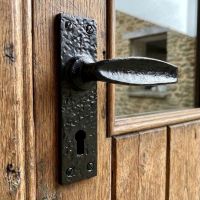 The "Acerno" Scrolled Lever Lock Door Handle on an External Wooden Door on a Country Home - Digital Illustration 