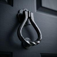 The "Annora" Pear Shaped Door Knocker  on a Dark Blue Coloured Timber Door - Digital Illustration