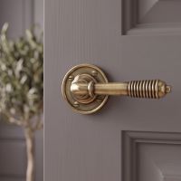 The "Balcroft" Antique Brass Beehive Lever Handles on a Grey Door in a Modern Home - Digital Illustration