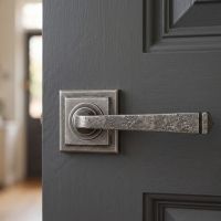 The "Barnsley" Pewter Round Lever Door Handle on Square Rose on a Dark Grey Wooden Door - Digital Illustration