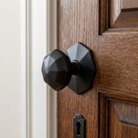 The "Beaufort" Matte Black Octagonal Centre Door Knob on a Classic Wooden Door in a Traditional Home - Digital Illustration 