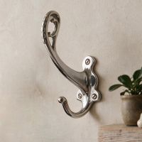 The "Becksly Park" Loop Hook with Shaped Backplate in Bright Chrome on a Textured Wall - Digital Illustration 