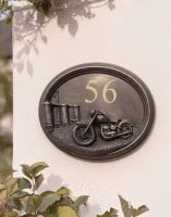 The "Chopper" Classic Motorbike House Sign Mounted on the Outside of a House next to some Plants The "Chopper" Classic Motorbike House Sign Mounted on the Outside of a House next to some Plants