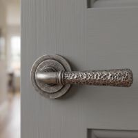 The "Clarissa" Pewter Hammered Lever Door Handle on Art Deco Rose Mounted on a Grey Door in a Country Home - Digital Illustration 