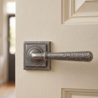 The "Clarissa" Pewter Hammered Lever Door Handle on Square Rose Shown Mounted on a Cream Coloured Door - Digital Illustration