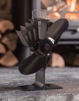 The 22cm Black "UltrAir" Eco Wood Stove Fan in Front of a Burning Log Fire Stove - Digital Illustration The 22cm Black "UltrAir" Eco Wood Stove Fan in Front of a Burning Log Fire Stove - Digital Illustration