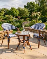 The "Draycott" 2-Seater Rattan Outdoor Dining Set in Situ in the Garden digital illustration dressed table