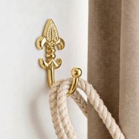The "Fleur De Ly’s" Curtain Tie Back Fitted on a Modern White Interior Wall Next to a Brown Curtain - Digital Illustration The "Fleur De Ly’s" Curtain Tie Back Fitted on a Modern White Interior Wall Next to a Brown Curtain - Digital Illustration