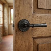 The "Franbury" Black Hammered Lever Door Handle on Beehive Rose on a Traditional Wooden Door in a Stone Cottage - Digital Illustration