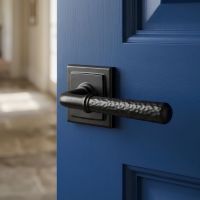 The "Franbury" Black Hammered Lever Door Handle on Square Rose on a Dark Blue Wooden Door in a Sun Lit Corridor - Digital Illustration 