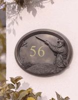 The "Game & Grouse" Bronze Finish Game Season House Sign next to Garden Plants on a Wall - Digital Illustration 