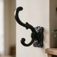 The "Hebeney Court" Black Iron Coat Hook Shown Close up on a Magnolia Coloured Wall - Digital Illustration