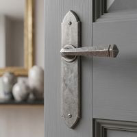 The "Orelia" Pewter Gothic Latch Lever Set  on a Light Grey Door in a Modern Living Room - Digital Illustration