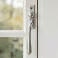 The "Regency" Satin Chrome Teardrop Espagnolette Window Fastener Fitted on a White Painted Window Frame - Digital Illustration The "Regency" Satin Chrome Teardrop Espagnolette Window Fastener Fitted on a White Painted Window Frame - Digital Illustration
