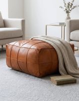 The "The Wickesbury" Tan Leather Floor Pouffe in a Living Room with a Blanket Draped over it - Digital Illustration The "The Wickesbury" Tan Leather Floor Pouffe in a Living Room with a Blanket Draped over it - Digital Illustration