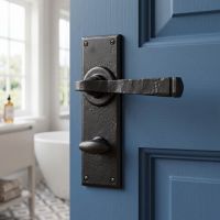 The "Thornton" Black Finish Lever Handle With Thumb Lock on a Blue Bathroom Door - Digital Illustration
