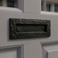 The "Torriedale" 10.5" Black Cast Iron Letter Plate on a Grey Home Door Entrance - Digital Illustration 