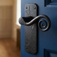 The "Ververt" Beeswax Monkey tail Lever Latch Set on a Dark Blue Door in an Upstairs Home Corridor - Digital Illustration 