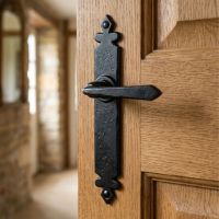 The "Vittoria" Black Tudor Sprung Lever Latch Set  in a Cottage Mounted on a Timber Door - Digital Illustration