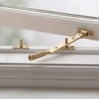 The 248mm 8" Satin Brass "Royale" Three Pin Window Stay Fitted on a Classic White Wooden Window Frame - Digital Illustration The 248mm 8" Satin Brass "Royale" Three Pin Window Stay Fitted on a Classic White Wooden Window Frame - Digital Illustration