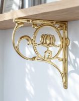 The 25 x 23cm "Lotus Flower" Polished Brass Shelf Bracket Mounted on a White Kitchen Wall in a Contemporary Home - Digital Illustration 