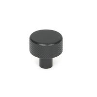 The 25mm "Vesper" Knurled Edge Cabinet Knob in Matt Black on a White Background Shown Stood Upright