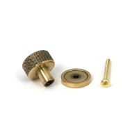 The 25mm Knurled Cabinet Knob on a Plain Rose in Aged Brass with Fitting Bolt on a White Background The 25mm Knurled Cabinet Knob on a Plain Rose in Aged Brass with Fitting Bolt on a White Background