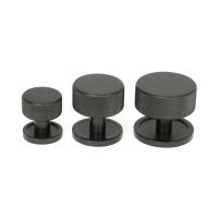 The 25mm Knurled Cabinet Knob on a Plain Rose in Aged Bronze Alongside Different Sizes The 25mm Knurled Cabinet Knob on a Plain Rose in Aged Bronze Alongside Different Sizes