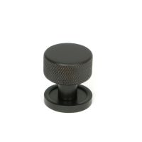 The 25mm Knurled Cabinet Knob on a Plain Rose in Aged Bronze Shown Upright on a White Background The 25mm Knurled Cabinet Knob on a Plain Rose in Aged Bronze Shown Upright on a White Background