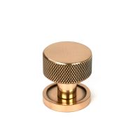 The 25mm Knurled Cabinet Knob on a Plain Rose in Polished Bronze Shown Upright on a White Background 