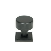 The 25mm Knurled Cabinet Knob on Square Rose in Matt Black Shown Upright on a White Background