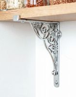 The 27cm x 22cm Entwined Scroll Bright Chrome Shelf Bracket Mounted on a White Coloured Kitchen Wall Supporting a Wooden Shelf - Digital Illustration The 27cm x 22cm Entwined Scroll Bright Chrome Shelf Bracket Mounted on a White Coloured Kitchen Wall Supporting a Wooden Shelf - Digital Illustration