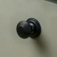 The 30mm "Garrison" Ribbed Beehive Knob in Matt Black Fitted on to a Sage Green Kitchen Cupboard - Digital Illustration