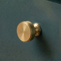 The 32mm "Atelier" Circular Cabinet Knob in Aged Brass Designed for Kitchen Cupboards on a Contemporary Cabinet Drawer - Digital Illustration