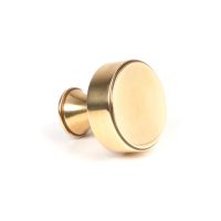 The 32mm "Atelier" Circular Cabinet Knob in Aged Brass on a White Background Shown Side on