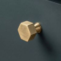 The 32mm "Vanguard" Hexagonal Cabinet Knob in Aged Brass Mounted on a Blue Kitchen Cupboard - Digital Illustration