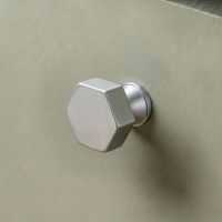 The 32mm "Vanguard" Hexagonal Cabinet Knob in Satin Chrome Displayed on a Sage Green Kitchen Cabinet Drawer - Digital Illustration