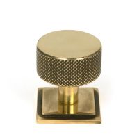 The 32mm Knurled Cabinet Knob on Square Rose in Aged Brass Shown Upright on a White Background The 32mm Knurled Cabinet Knob on Square Rose in Aged Brass Shown Upright on a White Background