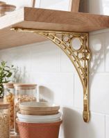 The 33 x 33cm Large Polished Brass "Iron Bridge" Shelf Bracket Mounted on a White Tiled Kitchen in a Modern Home - Digital Illustration 