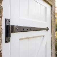 The 35" Cranked Cast Iron Door Hinges Fitted onto a Traditional Garage Side Door made from Wood - Digital Illustration 
