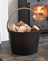 The 38cm Black & Gold Dimpled Steel Log Basket on a Traditional Stone Hearth next to a Lob Burner Stove - Digital Illustration