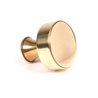 The 38mm "Atelier" Circular Cabinet Knob in Aged Brass on a White Background Shown Side On