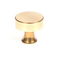 The 38mm "Atelier" Circular Cabinet Knob in Aged Brass on a White Background Shown Upright