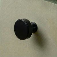 The 38mm "Atelier" Circular Cabinet Knob in Matt Black Designed for Kitchen Cupboards Mounted on a Green Drawer - Digital Illustration The 38mm "Atelier" Circular Cabinet Knob in Matt Black Designed for Kitchen Cupboards Mounted on a Green Drawer - Digital Illustration